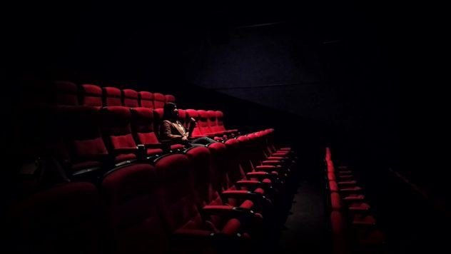 woman sitting alone in theater.
