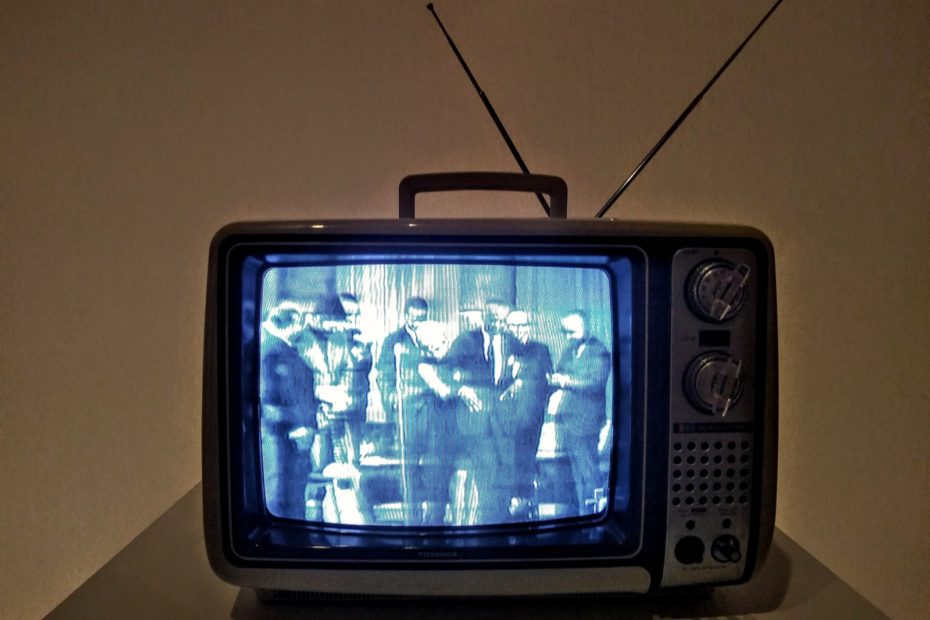 black crt tv turned on on white table